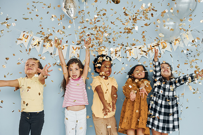 Home balloons and confetti. children on celebrating birthday party indoors have fun together